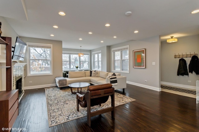 living room with dark hardwood / wood-style flooring and a tile fireplace