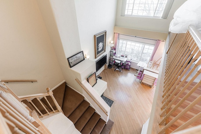 staircase featuring wood-type flooring and a towering ceiling