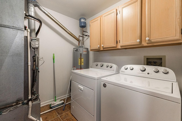 clothes washing area featuring gas water heater, dark tile patterned floors, washer and dryer, cabinets, and heating unit