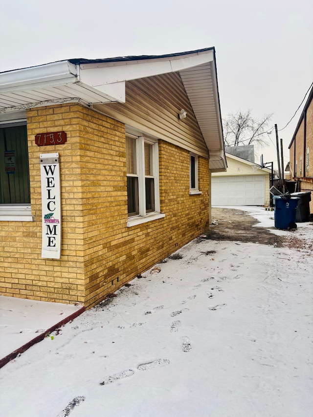 snow covered property with a garage