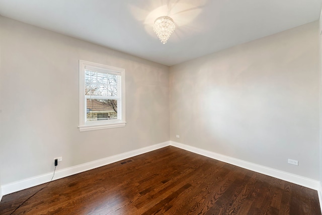 unfurnished room with an inviting chandelier and hardwood / wood-style flooring