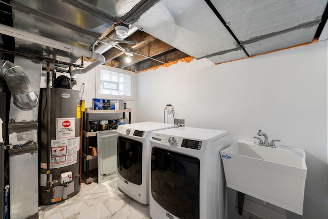 washroom with sink, separate washer and dryer, and water heater