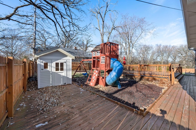 wooden deck with a playground and a storage shed