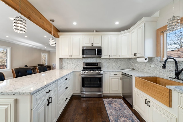 kitchen featuring white cabinetry, kitchen peninsula, stainless steel appliances, tasteful backsplash, and decorative light fixtures