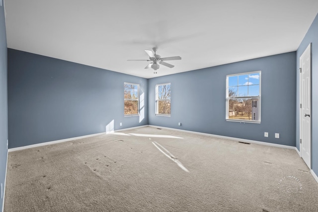 carpeted empty room featuring ceiling fan and a healthy amount of sunlight