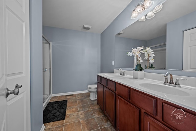 bathroom featuring vanity, a shower with shower door, and toilet