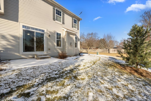 view of snow covered rear of property