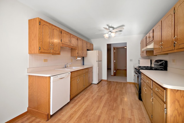 kitchen featuring decorative backsplash, sink, white appliances, and light hardwood / wood-style flooring