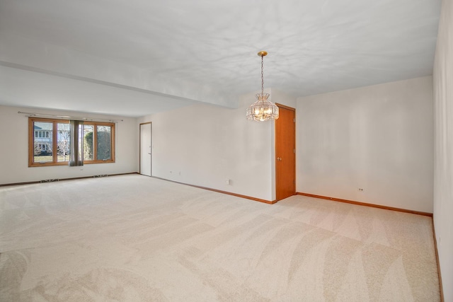 empty room featuring light colored carpet and a notable chandelier