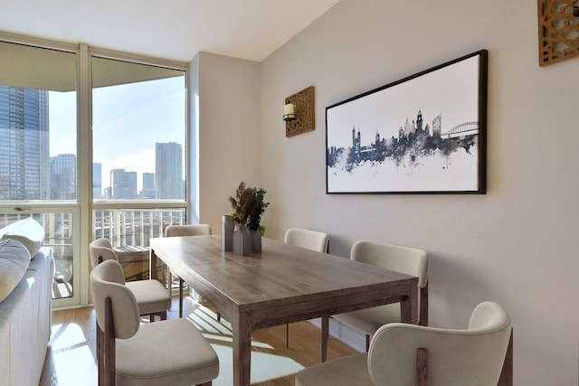 dining space with hardwood / wood-style floors and expansive windows