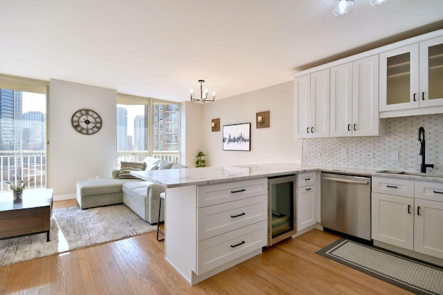 kitchen with white cabinetry, dishwasher, wine cooler, decorative backsplash, and kitchen peninsula