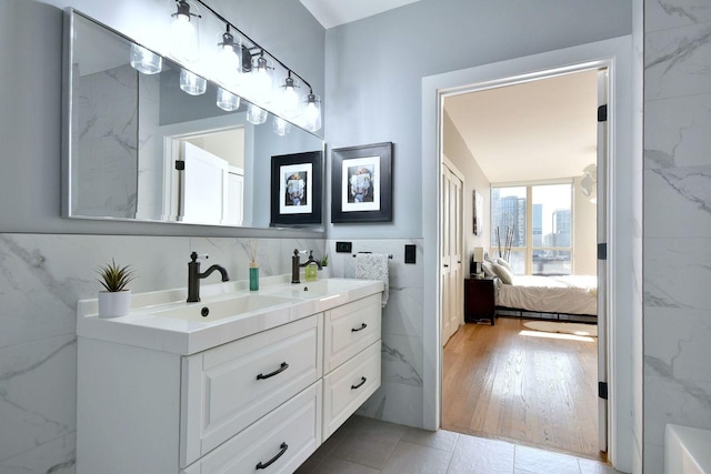 bathroom featuring tile patterned flooring, vanity, and tile walls