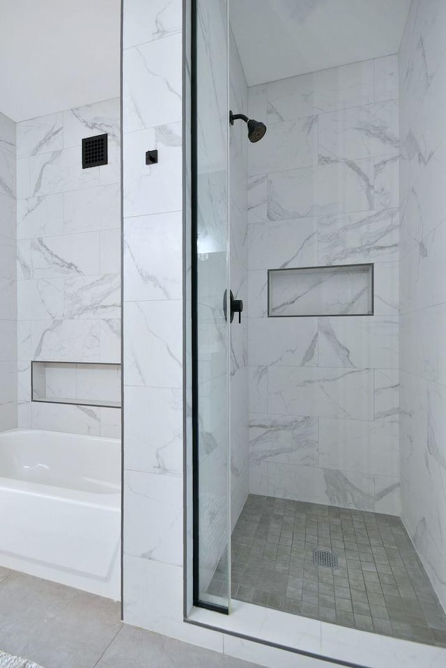 bathroom featuring tile patterned floors and separate shower and tub