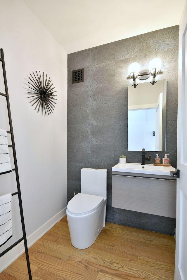 bathroom with vanity, hardwood / wood-style floors, a chandelier, and toilet