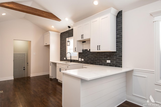 kitchen with decorative light fixtures, tasteful backsplash, vaulted ceiling with beams, white cabinetry, and light stone counters