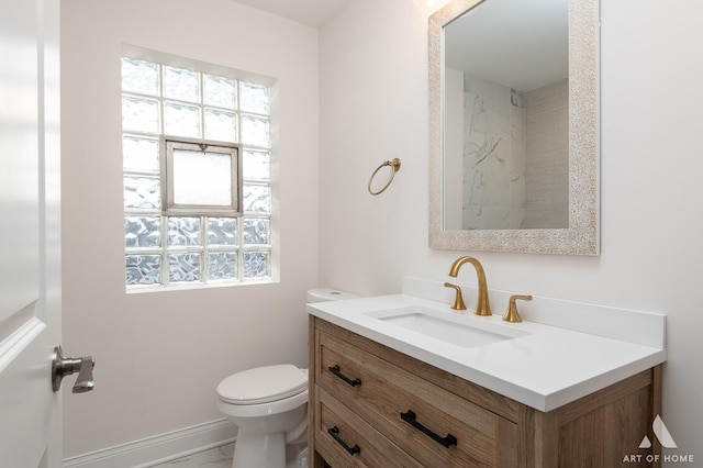 bathroom with plenty of natural light, toilet, and vanity