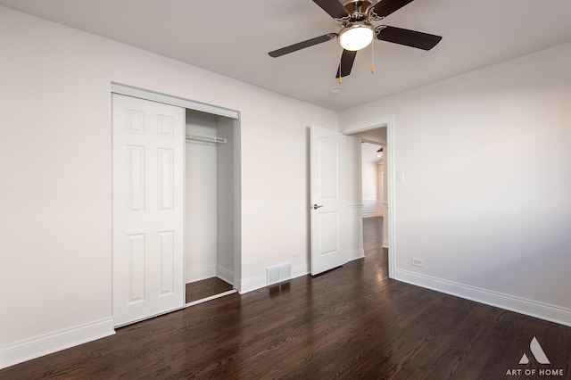 unfurnished bedroom featuring ceiling fan, a closet, and dark wood-type flooring