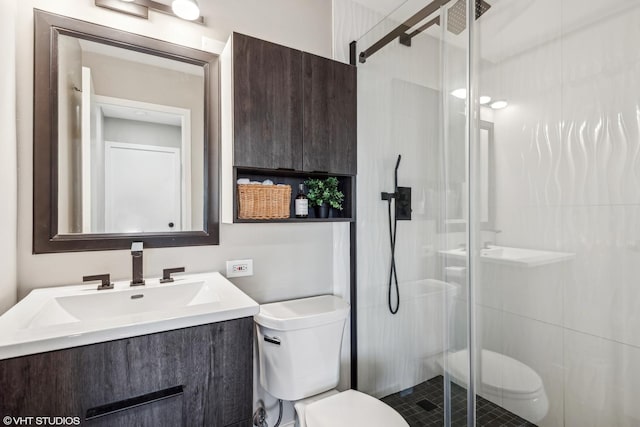 bathroom featuring toilet, vanity, and a shower with door