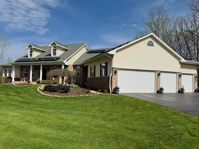 cape cod-style house featuring an attached garage, brick siding, a front yard, roof mounted solar panels, and concrete driveway