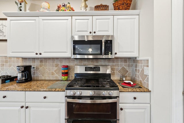 kitchen featuring stainless steel appliances, stone counters, white cabinetry, and decorative backsplash