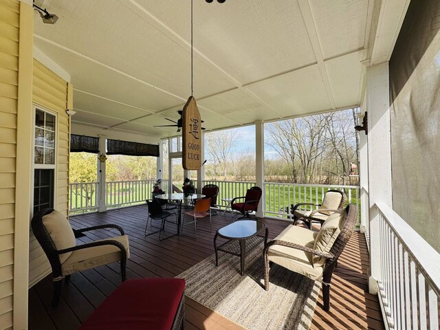sunroom / solarium featuring a ceiling fan