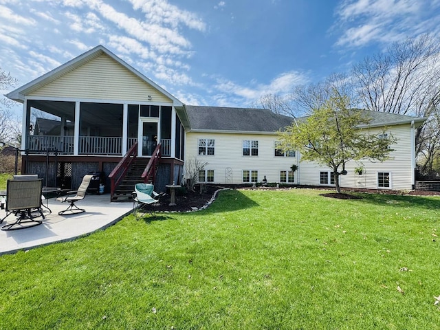 rear view of property featuring a patio, a lawn, stairs, and a sunroom