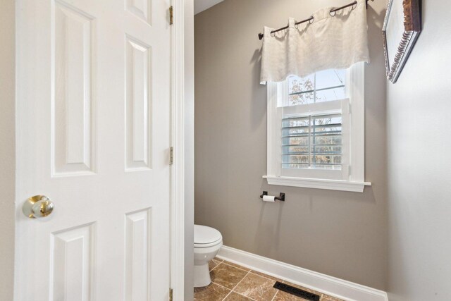 bathroom featuring toilet, baseboards, visible vents, and tile patterned floors