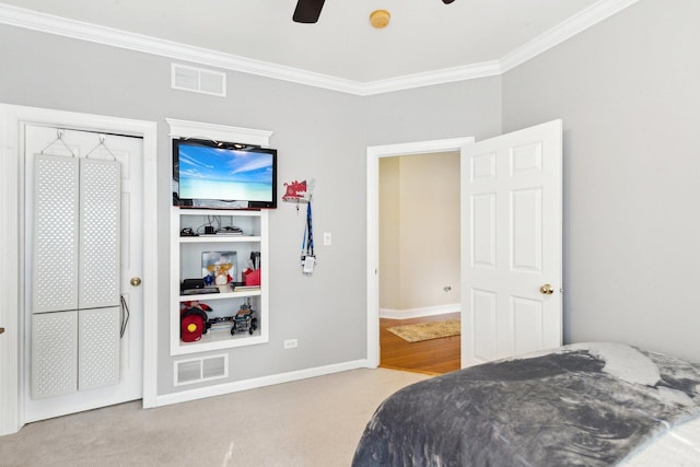 carpeted bedroom with baseboards, visible vents, ceiling fan, and ornamental molding