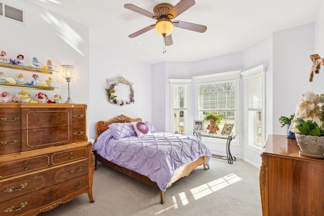 bedroom with baseboards, visible vents, ceiling fan, and light colored carpet