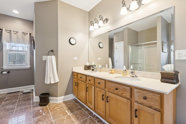 full bathroom featuring double vanity, baseboards, a shower stall, and a sink