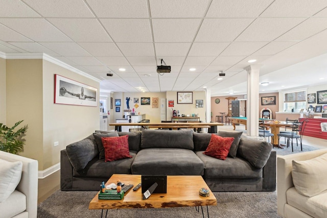 living room featuring crown molding, recessed lighting, baseboards, and decorative columns