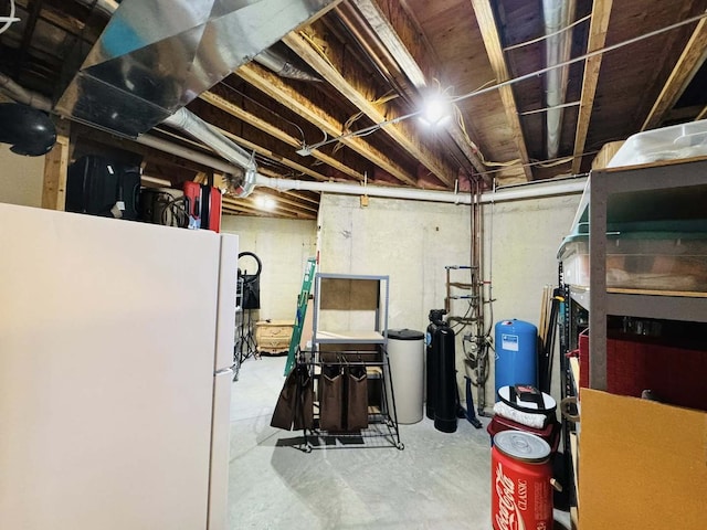 unfinished basement with freestanding refrigerator