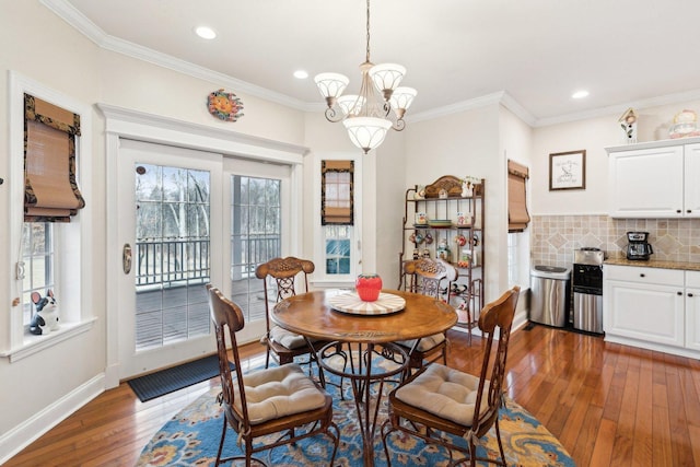 dining room with dark wood-style floors, a notable chandelier, crown molding, recessed lighting, and baseboards