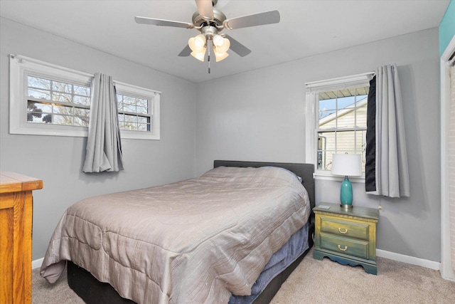 carpeted bedroom with multiple windows and ceiling fan