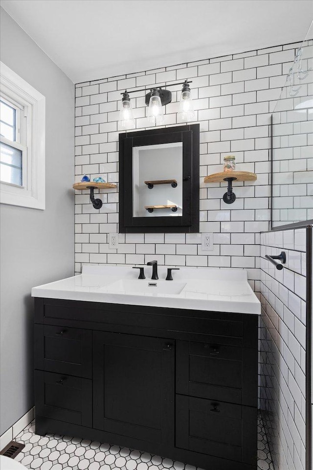 bathroom with vanity, backsplash, and tile walls