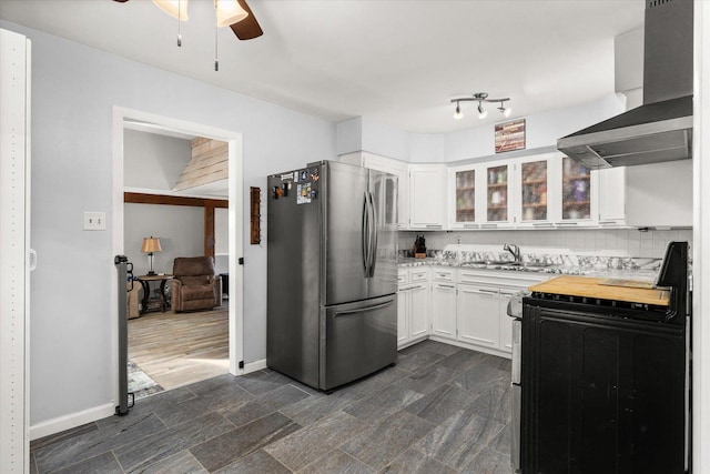 kitchen featuring stainless steel refrigerator, white cabinetry, sink, black range with electric cooktop, and wall chimney range hood