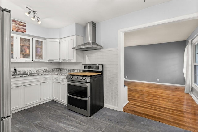 kitchen with dark hardwood / wood-style floors, white cabinetry, sink, stainless steel appliances, and wall chimney exhaust hood