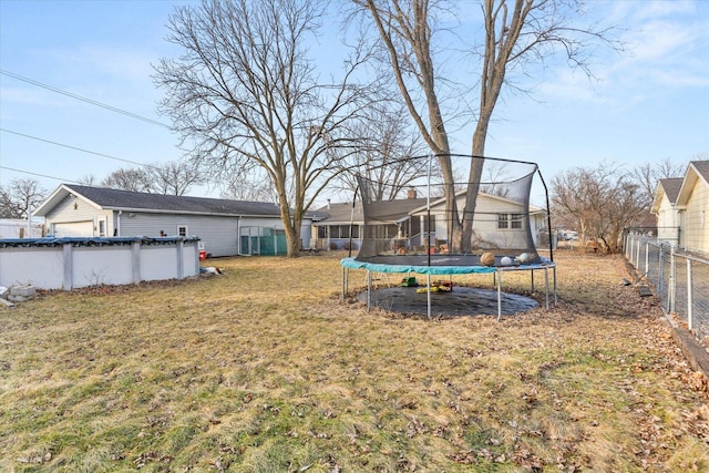 view of yard featuring a trampoline and a covered pool