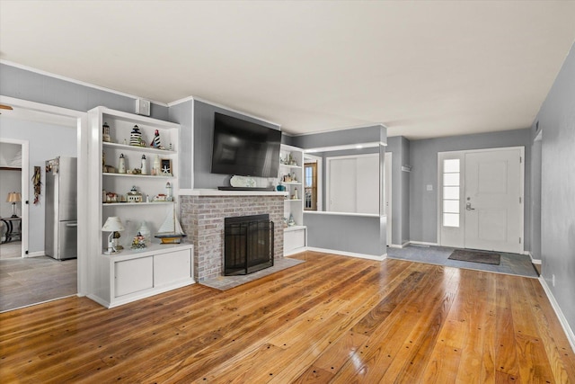 unfurnished living room featuring a brick fireplace and hardwood / wood-style flooring