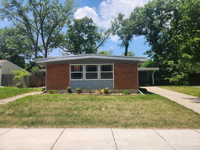 view of front of property with a front lawn and a carport