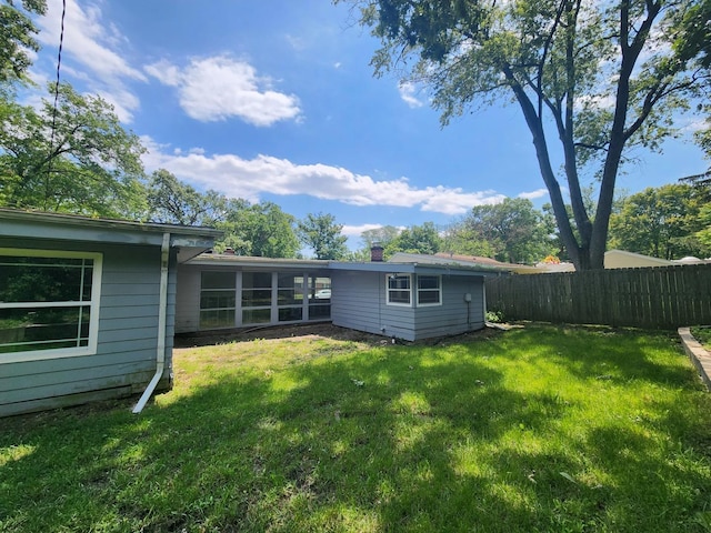 back of house with a lawn and a sunroom