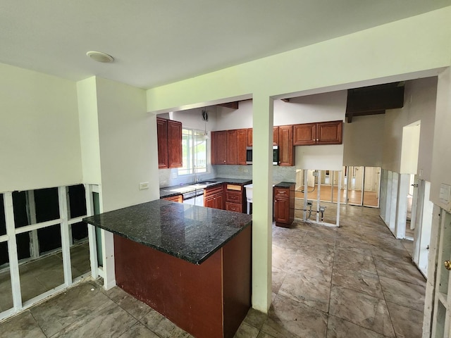 kitchen with dark stone counters, decorative backsplash, a kitchen breakfast bar, kitchen peninsula, and white dishwasher