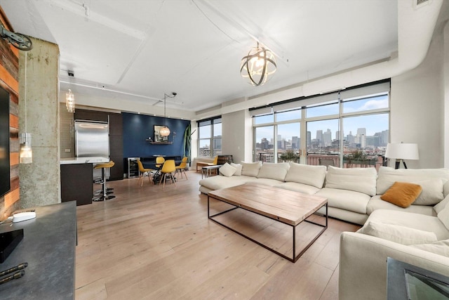 living room with a notable chandelier and light wood-type flooring