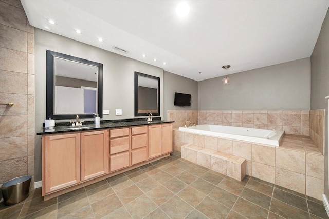 bathroom with tiled bath and vanity