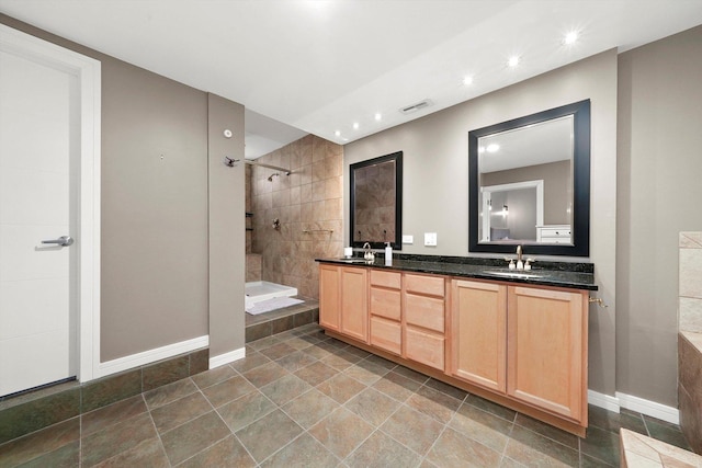 bathroom with a tile shower and vanity