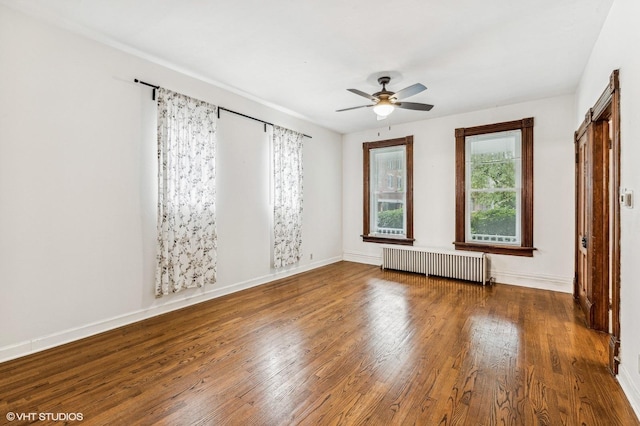 empty room with ceiling fan, radiator, and wood-type flooring