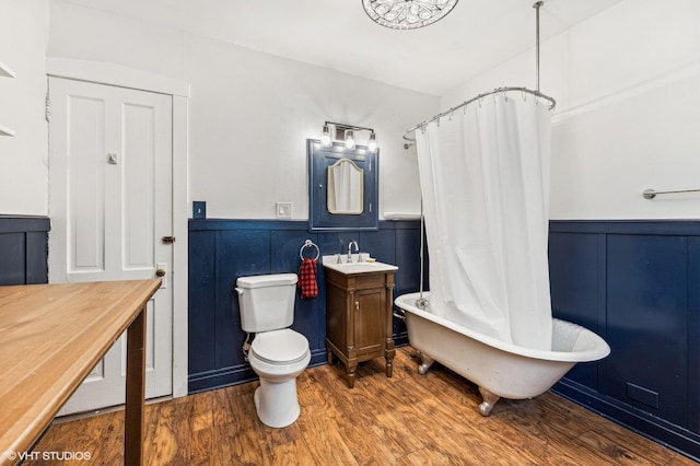 full bathroom with toilet, hardwood / wood-style floors, vanity, and shower / tub combo with curtain