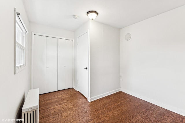 unfurnished bedroom with dark hardwood / wood-style floors and a closet