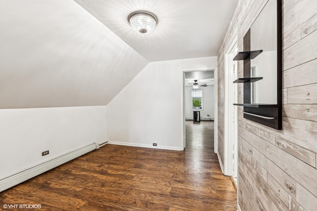 bonus room featuring baseboard heating, dark wood-type flooring, wood walls, and vaulted ceiling