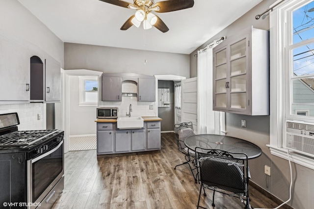 kitchen featuring stainless steel appliances, gray cabinetry, tasteful backsplash, wood-type flooring, and sink